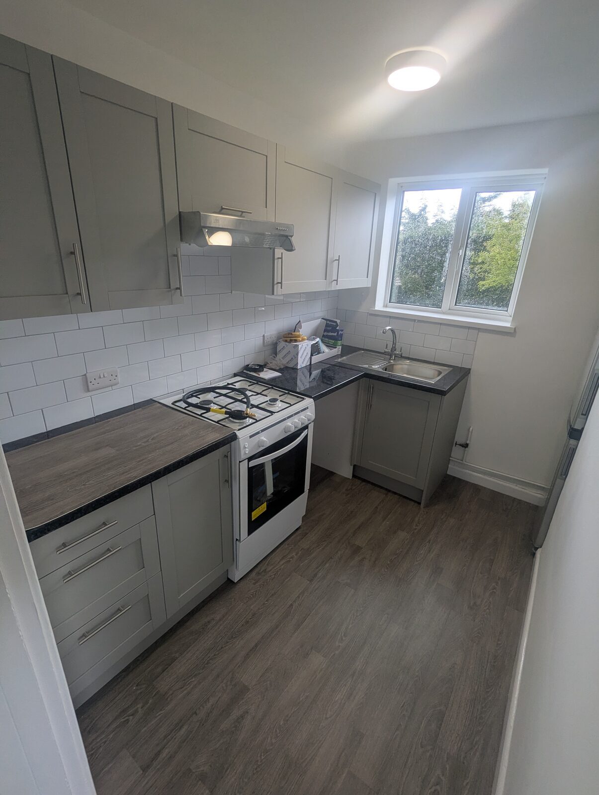 Light grey shaker kitchen with wood-effect flooring